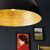Metal pendant illumating a simple gallery wall