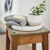Rustic bathroom stool with towel, plant and soap in a tray on it