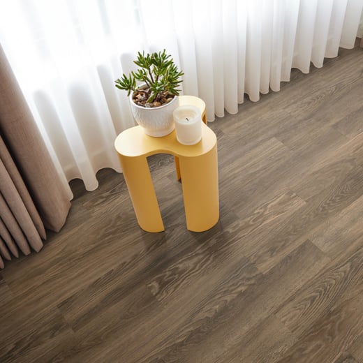 Cocoa limed oak dark brown lvt flooring laid in a living area next to a window